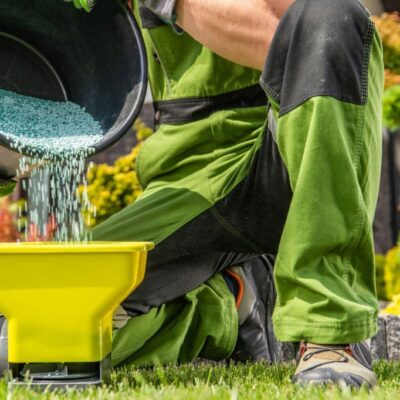 An expert lawncare provider preparing fertilizer to be spread out.