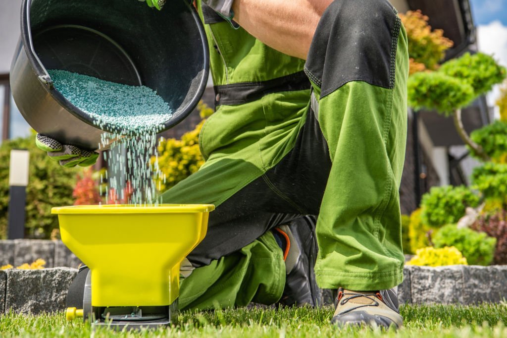 An expert lawncare provider preparing fertilizer to be spread out.