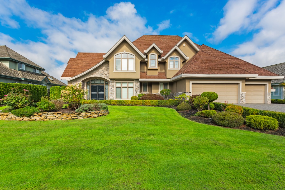 A beautiful home with a well - kept lawn that is taken care of by professionals on a routine basis.