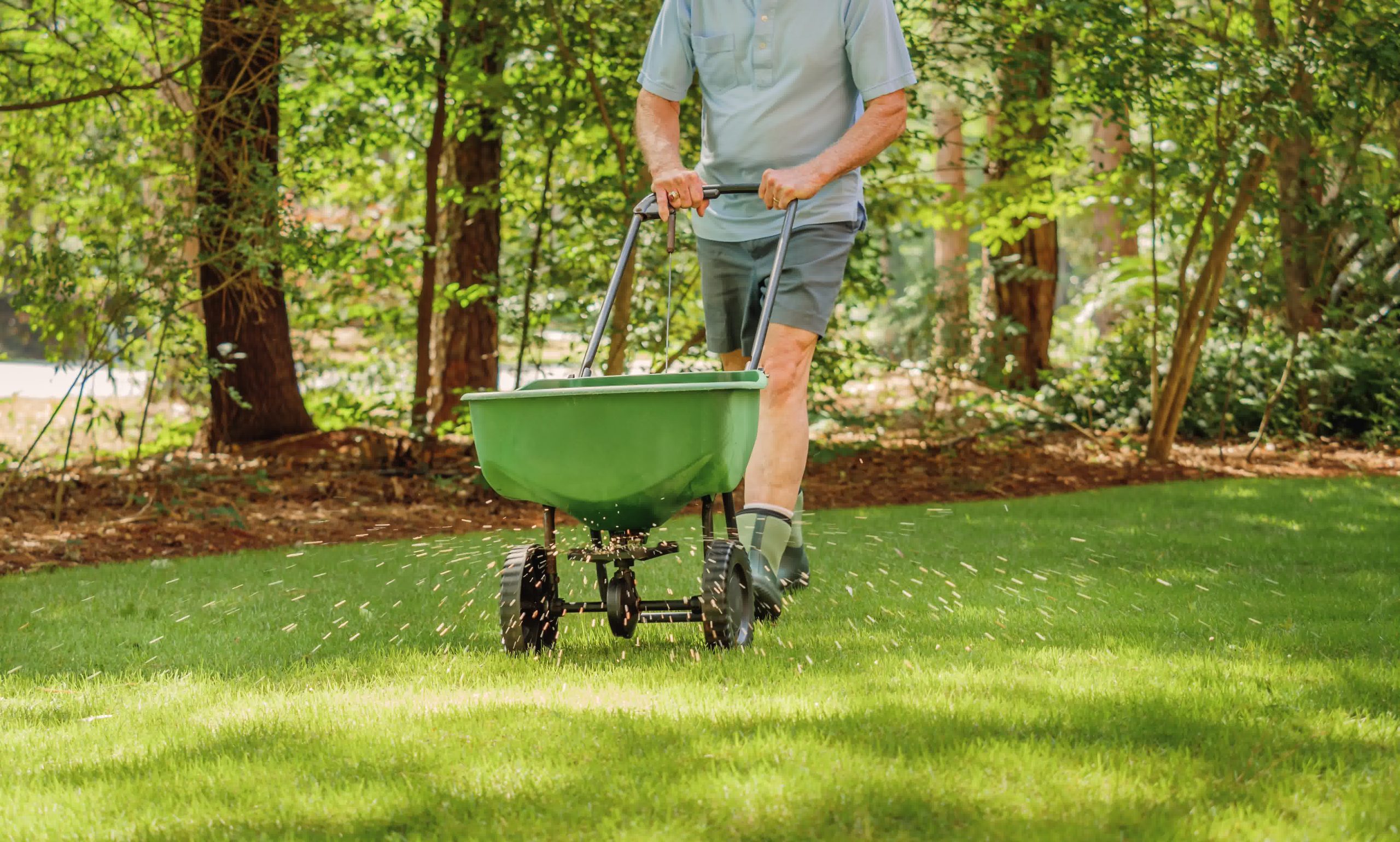 A professional landscaper taking care of a quick fertilizing service.